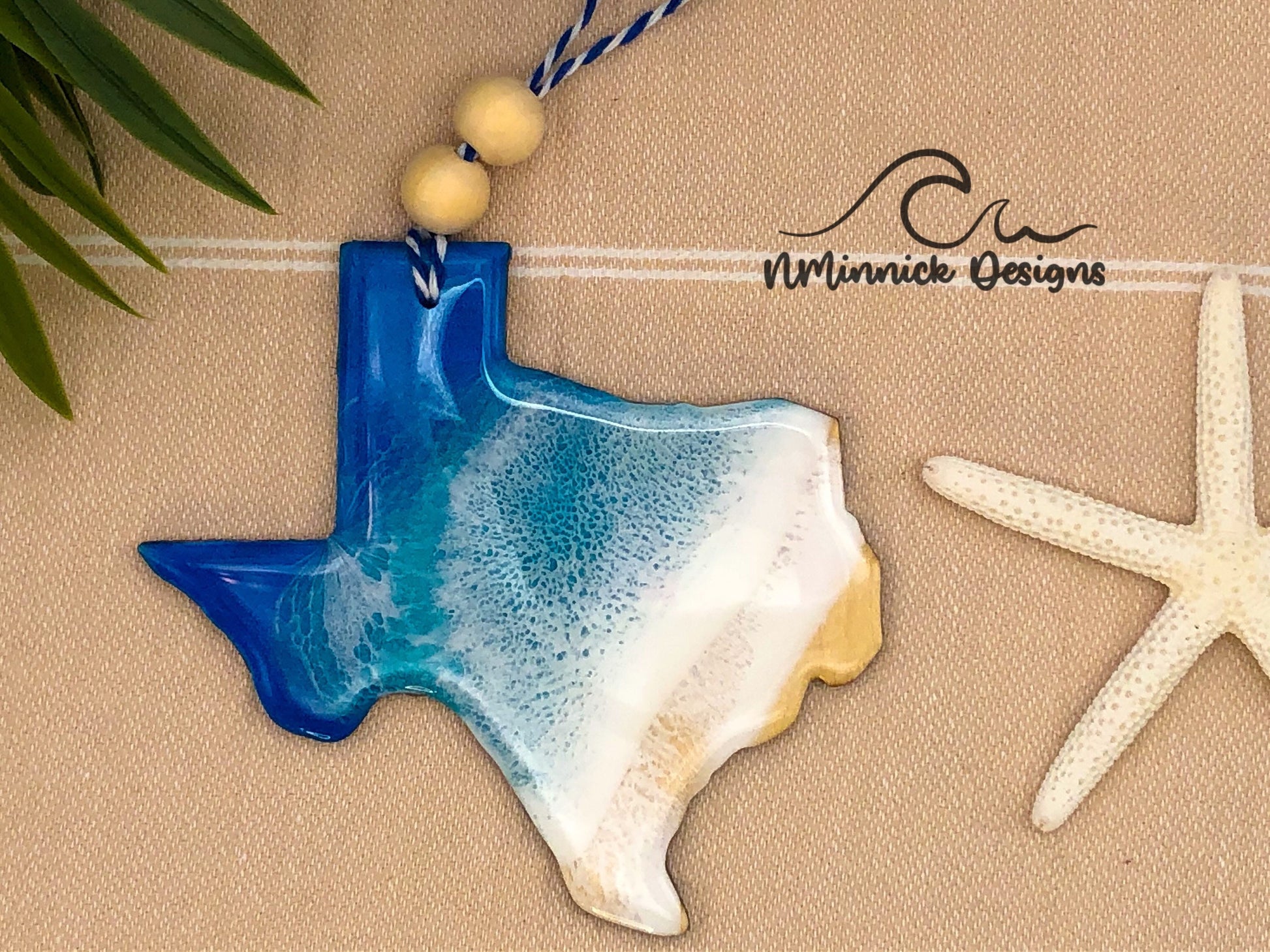 Texas shaped laser cut wood ornament. 1/8 inch thick and approximately 4-4.5 inches wide. Covered in epoxy resin with blue, teal, and white to make it look like waves on a beach.