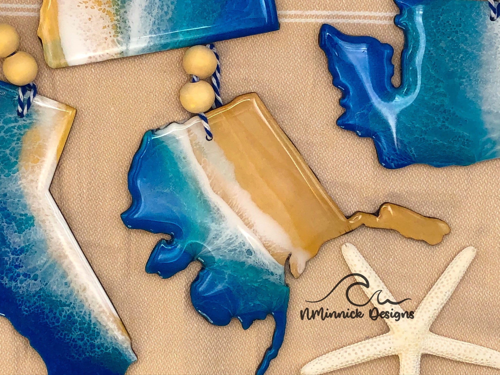 Alaska ocean resin ornament. 4 to 4.5 inch laser cut wood ornament with multiple layers of epoxy resin to create a one of a kind ocean scene. Colors are dark blue, okinawa blue and white. 1/8 inch thick.