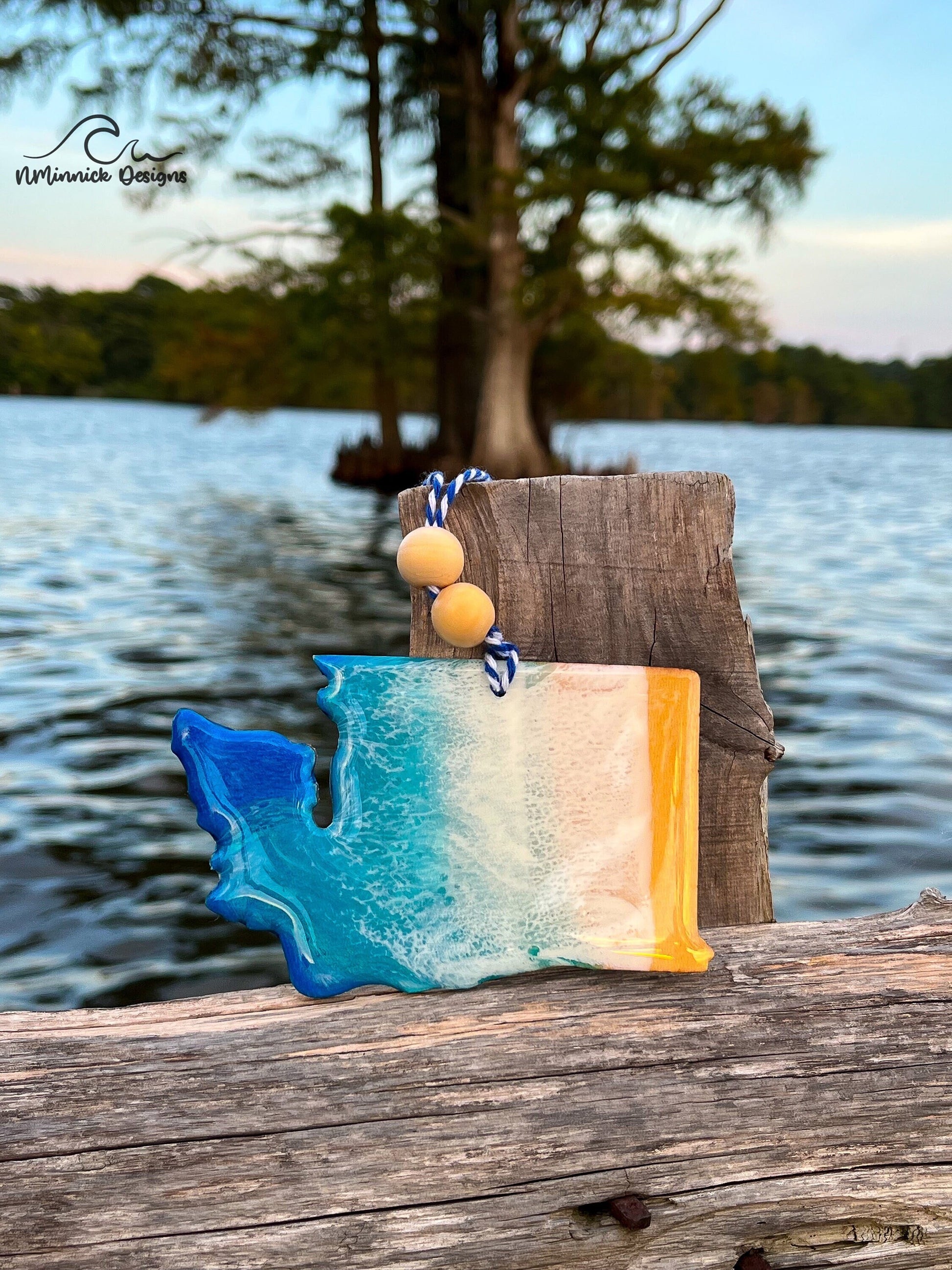 Washington State-shaped wooden Christmas ornament covered in blue and teal colored ocean resin art resembling the waves along Washington&#39;s Pacific Coast. Finished with blue and white baker&#39;s twine and two wooden beads.