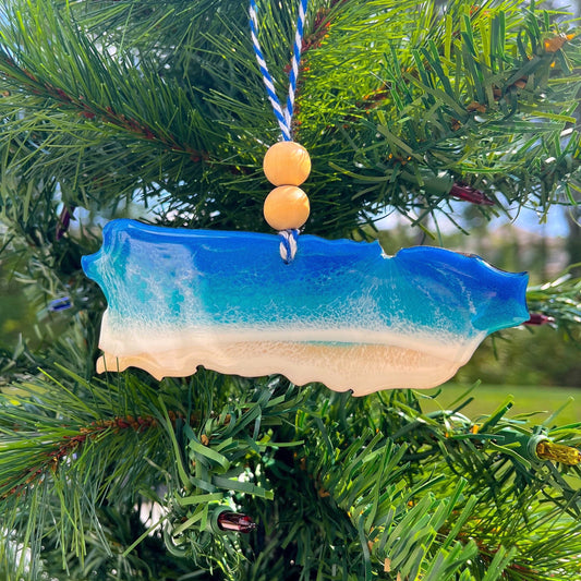 Puerto Rico shaped wooden ornament with blue and white ocean resin art hanging on a christmas tree