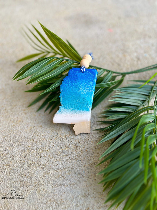 A Mississippi shaped wooden ornament with blue and white ocean resin art.