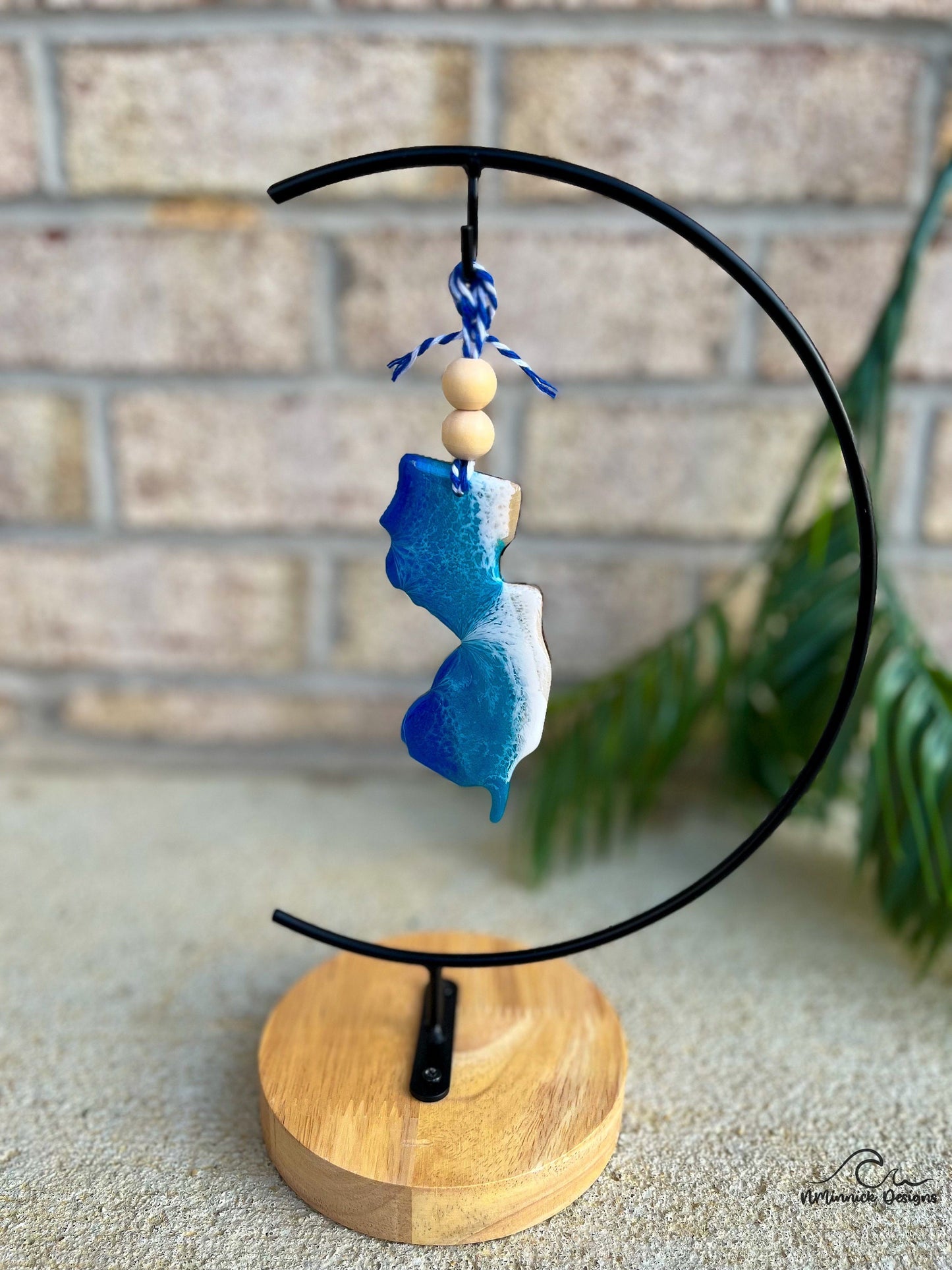 New Jersey ornament with ocean resin art hanging on an ornament stand.