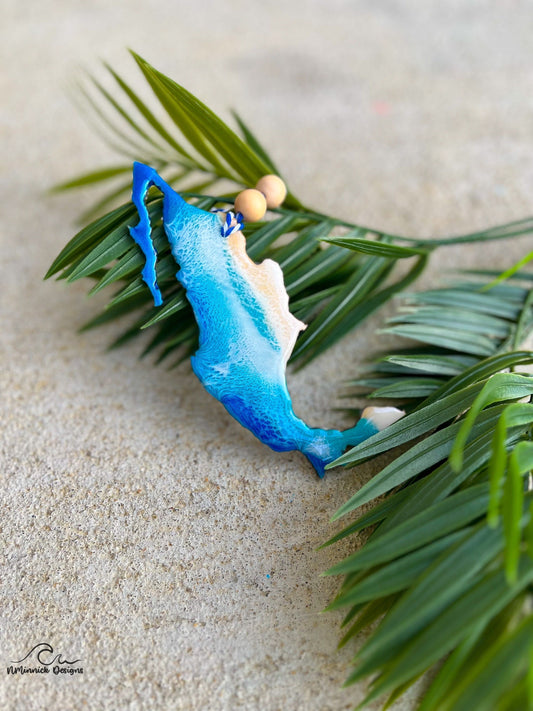 Mexico Ornament with Ocean Resin Art laying against palm leaves.