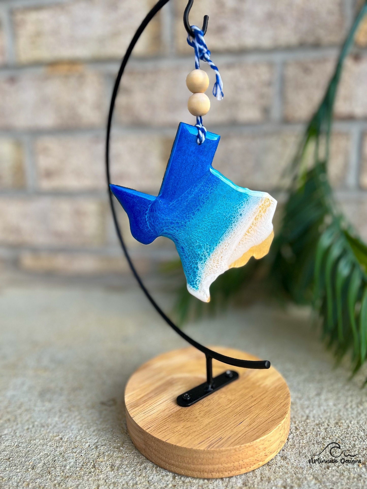 Texas ornament with ocean resin art hanging from an ornament stand.