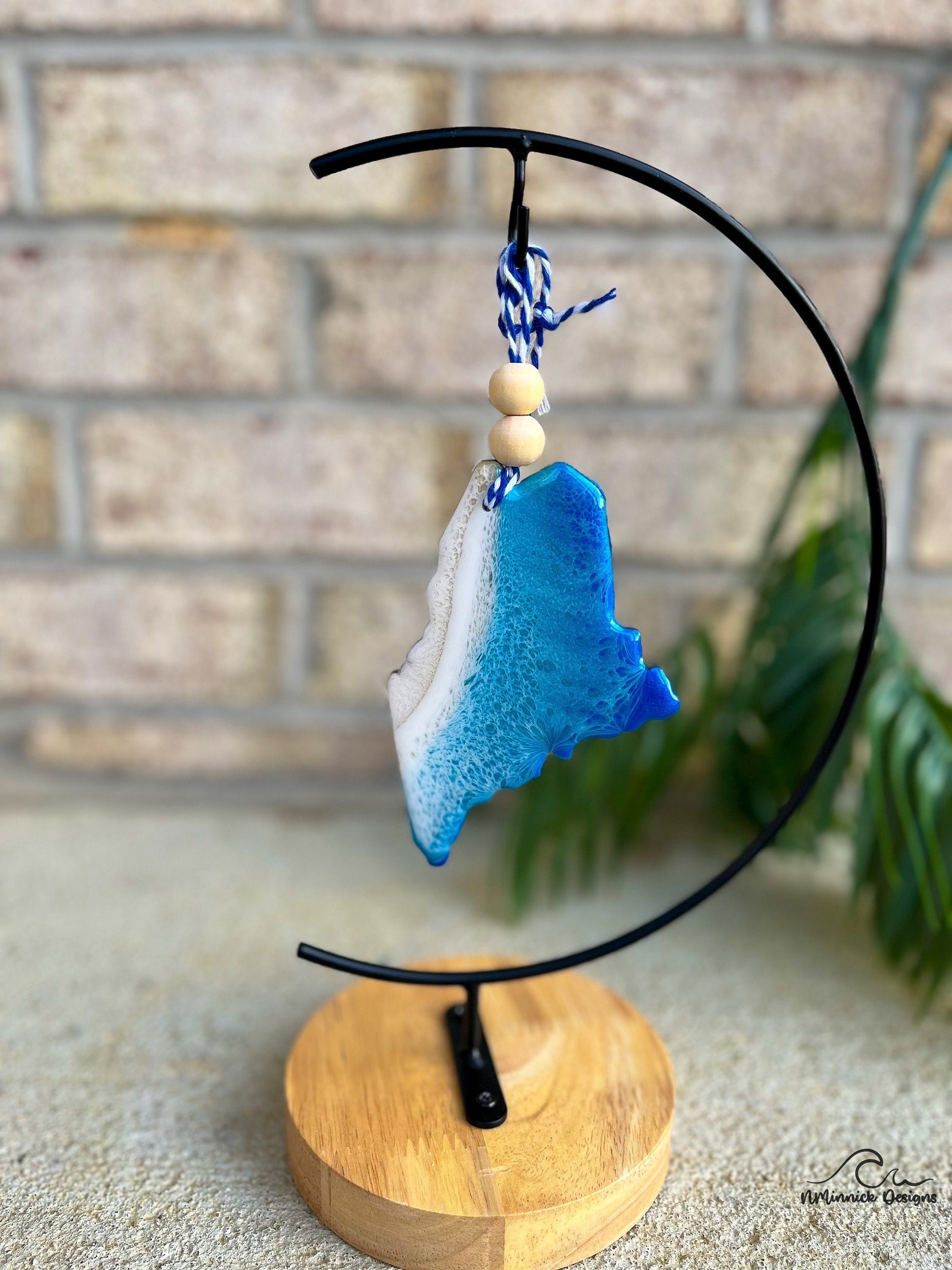 Maine ornament with ocean resin art hanging from an ornament stand.