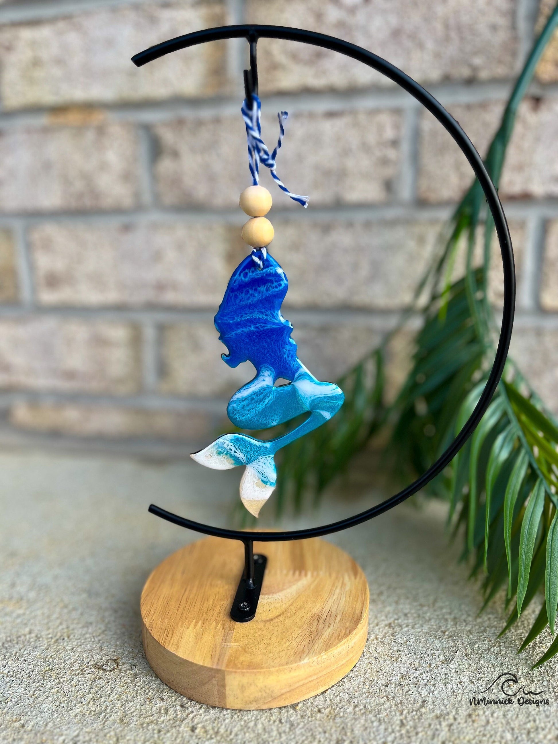 Mermaid shaped ornament with ocean resin art hanging from an ornament stand.