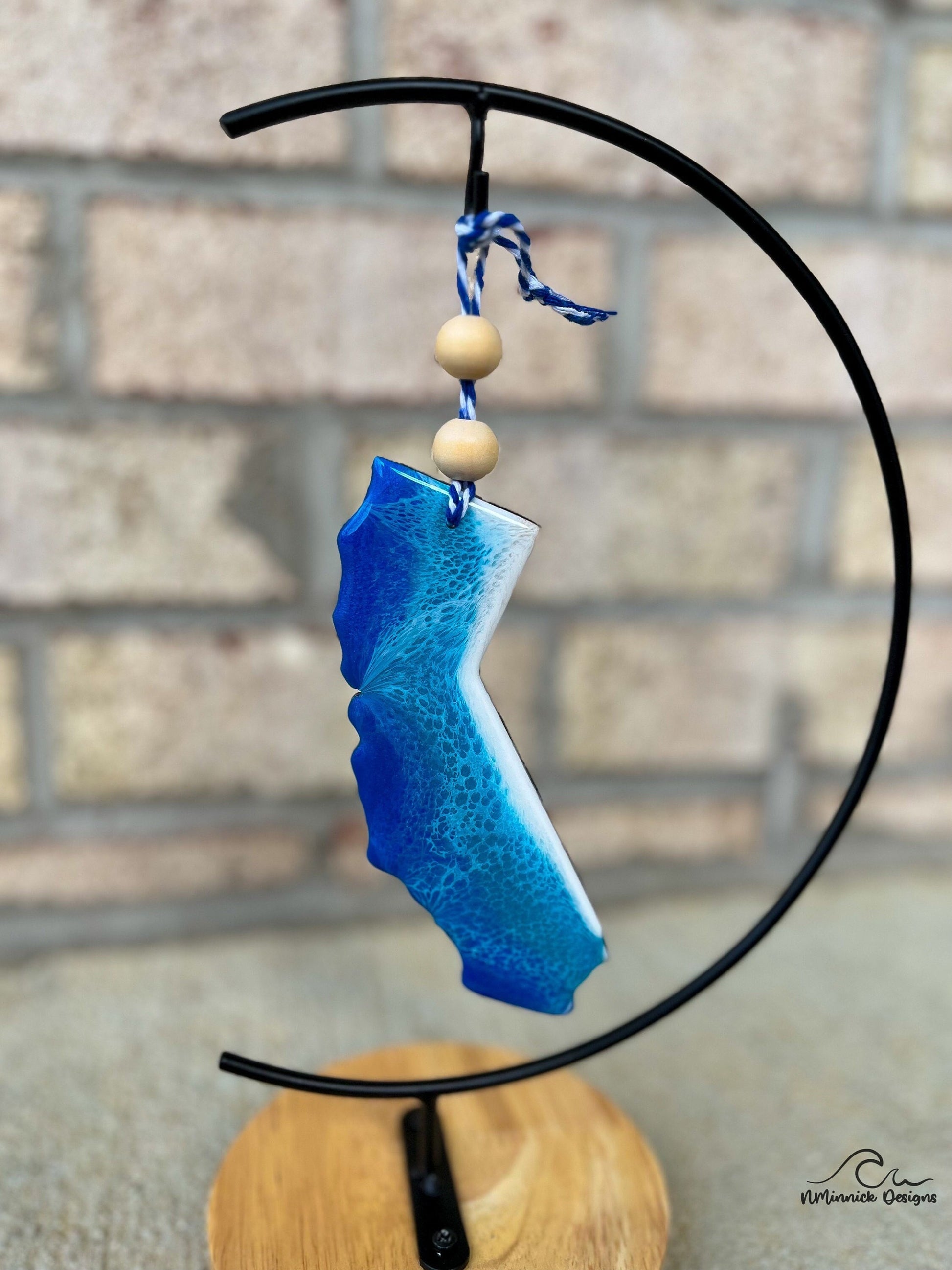 California coastal ornament with ocean wave art hanging from an ornament stand.