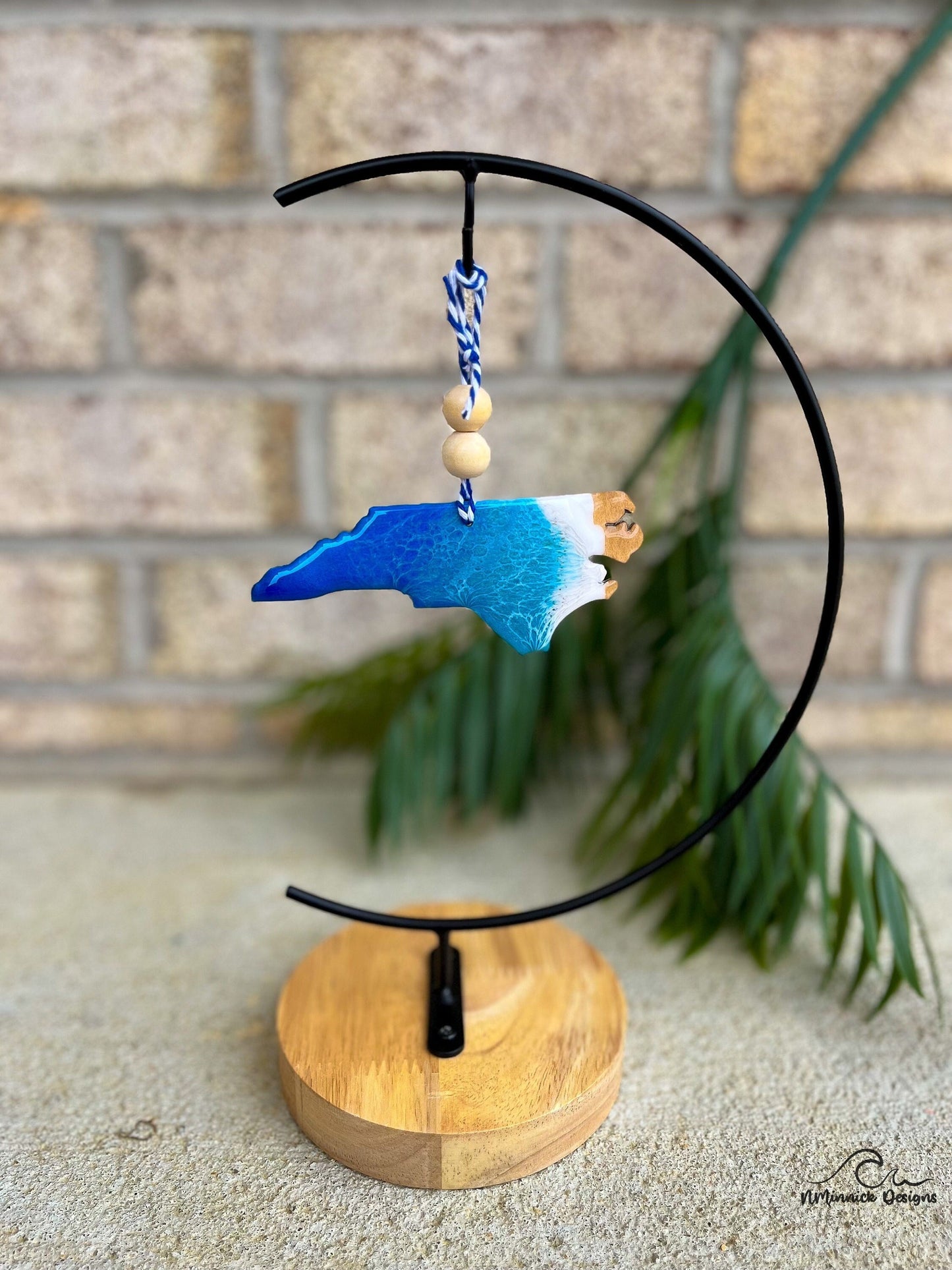 North Carolina ornament with blue and white ocean resin art hanging on an ornament stand.