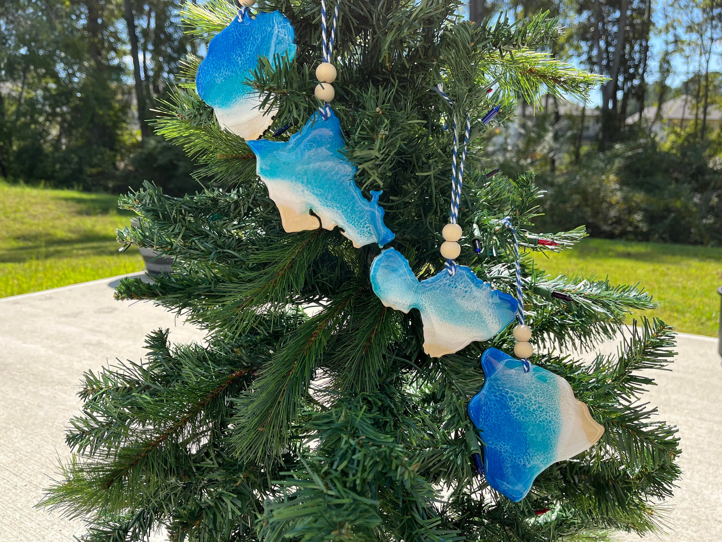 Hawaiian Island Ornaments with ocean resin art and hanging on a christmas tree.