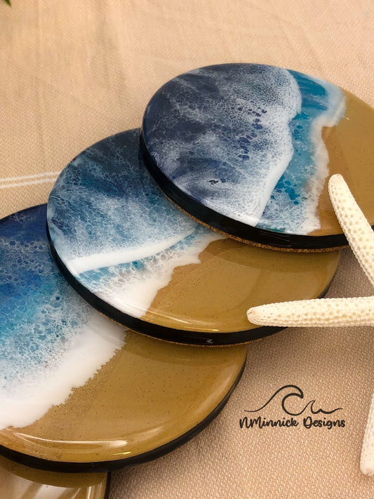 dark blue ocean coaster set of 4, ocean scene consisting of real beach sand and a dark blue ocean and white waves on the beach made with epoxy resin. Cork backing.